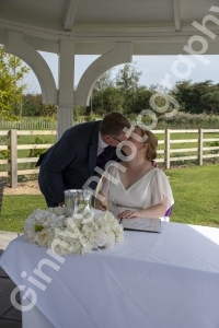 Bride and groom kissing after signing the register