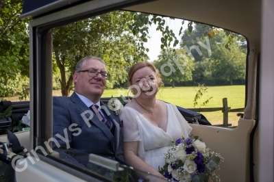 Bride and groom sat in their wedding car