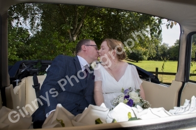 Bride and Groom kissing sat in their wedding car