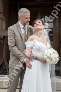 Bride and groom standing on the steps at cleethorpes registry office, looking at each other